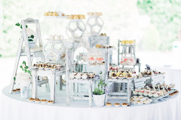 Beautiful candy bar made of little ladders and chairs served with sweets