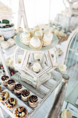 White cookies stand on a wooden chair on candy bar