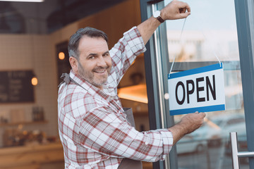 bartender hanging open sign on door