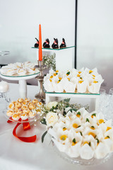 White desserts with yellow decor stand on the dinner table