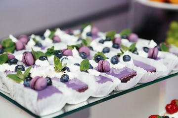 Blue desserts with violet macaroons and blueberries