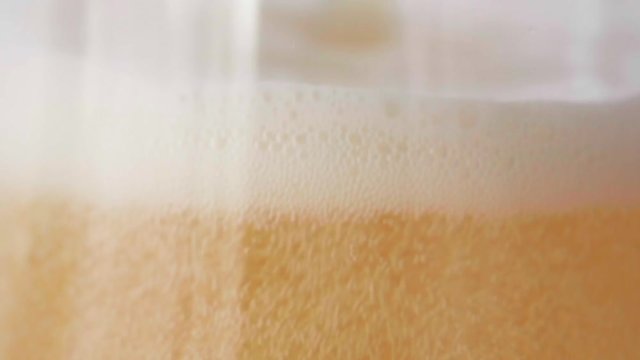 Beer is pouring into glass on white background