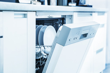 Open dishwasher with clean dishes in white kitchen © leszekglasner
