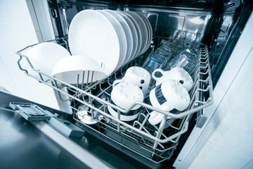 Open dishwasher with clean dishes close up