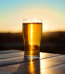 Crédence de cuisine en verre imprimé Bière Glass of beer on the sunset.