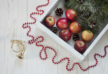 Christmas decor with apples on a white wooden background. Top view, background
