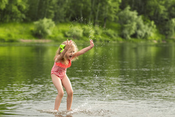 Litle girl playing in the water and making splash