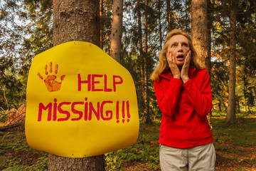 a sign hanging from a tree with the inscription help missing and / a sign hanging from a tree with the inscription help missing and a woman who wanders the woods