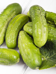 fresh organic cucumbers on a white wooden background.