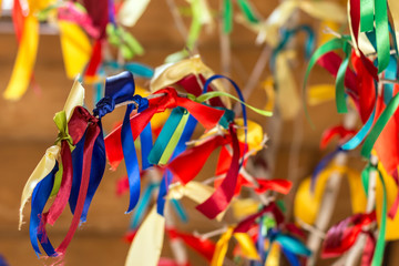 many colorful ribbons tied on tree branch