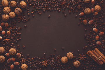 Brown background with walnuts, hazelnuts, anise, cinnamon and coffee beans