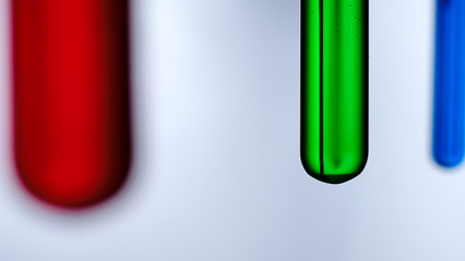 Test tubes with reagents on a white background. A test tube with a red, green and blue liquid on a white background.
