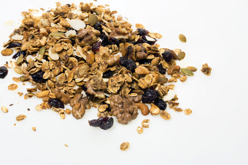 Homemade granola spilling from bowl on wooden table