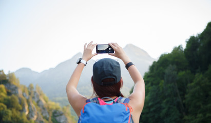 Photo from back of girl with backpack with smartphone