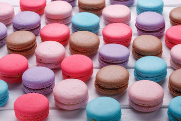 Fototapeta na wymiar Picture of a lot of sweet colorful macaroons on white wooden background.