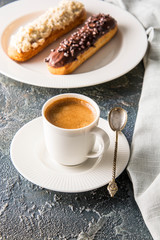 Assortment of eclairs with coffee , traditional french dessert. Copy space 