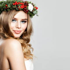 Naklejka premium Beautiful Christmas Woman. Happy Fashion Model with Christmas or New Year Decor Wreath with Xmas Tree Twig and Glass Balls