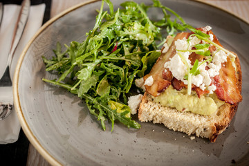 Tost z guacamole, bekonem i serkiem ricotta z sałatką z rukoli