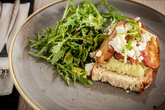 Tost z guacamole, bekonem i serkiem ricotta z sałatką z rukoli