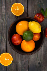 Citrus fruits in a wooden bowl, top view