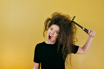 annoyed girl combs her hair - obrazy, fototapety, plakaty