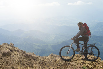 Fototapeta premium Biker riding on bicycle in mountains cyclist on the top of a hill
