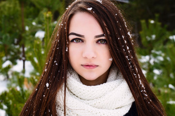 Close-up portrait of a girl in winter with snow on her hair