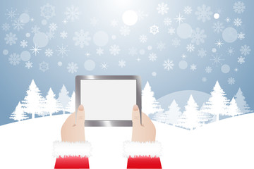 View of hands of Santa Claus holding tablet with blank screen ready for your text. Winter snowy  landscape is in the background. 