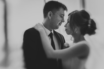 black white photo couple groom and bride against the background studio