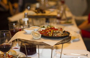 Served dishes to the table for holiday. Cutlery and food on white tablecloths in the restaurant. Design a festive Banquet. Luxurious food for guests and visitors.