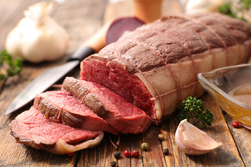 roast beef and spices on wood background
