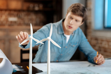 Young engineer touching wind turbine blade