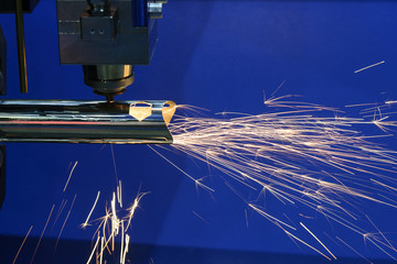 The fiber laser cutting machine cutting the steel pipe with the sparking light.The fire flame from the fiber laser cutting machine.