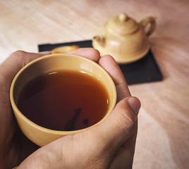 Close up the Chinese tea cup was holding by hand,blurry background,abstract art design,vintage and art style.