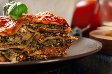 Piece of tasty hot lasagna with spinach on a plate