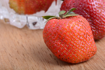 Close-up detail of a fresh red strawberry with leaves