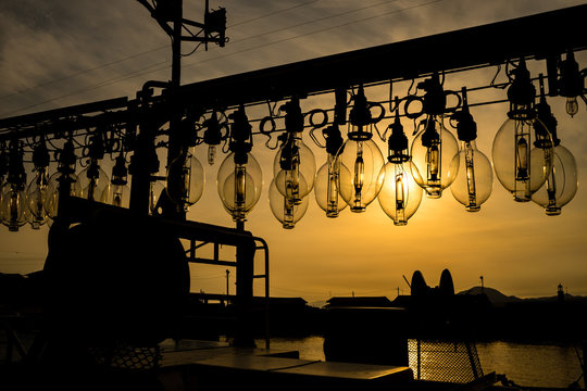 イカ釣り漁船の集魚灯と夕日
