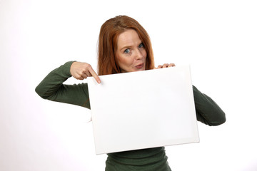Hübsche rothaarige Frau zeigt auf weisse Tafel