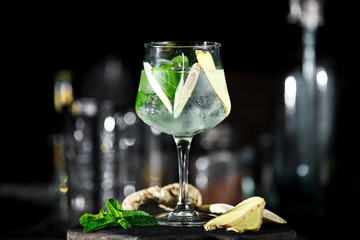 Ginger cocktail on dark background with mint and ice