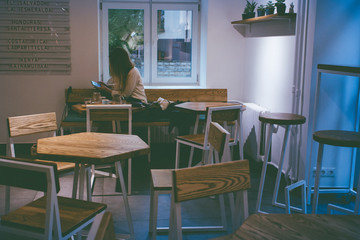 A girl with phone in the cafe