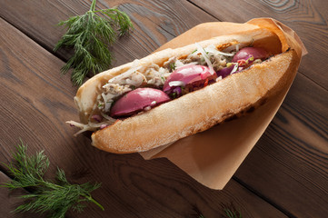 Street food, sandwich with pickled egg and fish on a wooden table