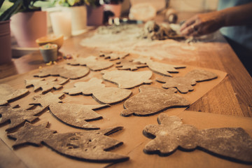 Woman making Christmas gingerbread cookies in kitchen