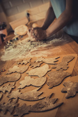 Woman making Christmas gingerbread cookies in kitchen