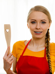 Woman holding wooden spatula with heart