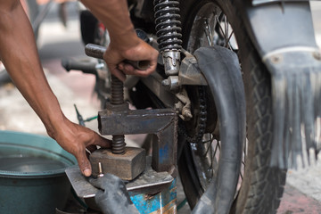 Motorbike tire replacement, installation on street side shop