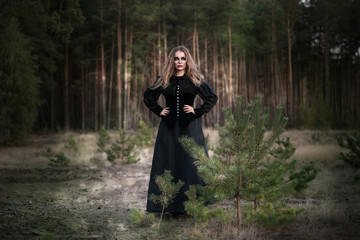 Obraz premium Halloween. piękna dziewczyna wiedźmy w lesie z dyni
