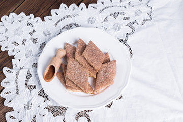 cookies with cinnamon on a lace napkin and a wooden table