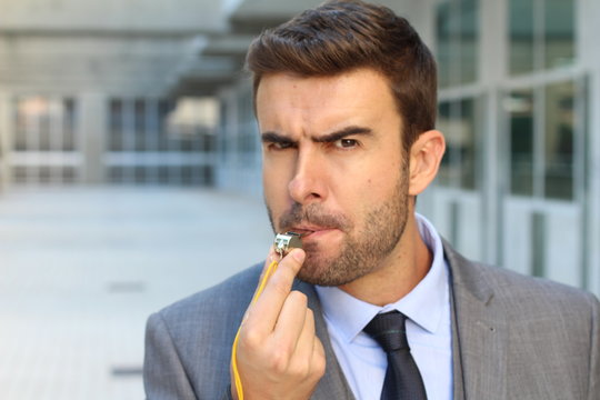 Mad businessman blowing a whistle