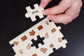 The concept of business, technology, the Internet and the network. A young businessman collects a puzzle with the proper inscription: IPv6