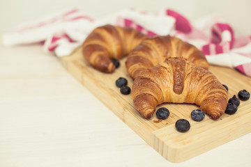 Croissants. Buns are on a wooden board. Baking. Sweets. Blueberries.